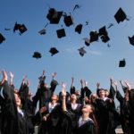 graduation party throwing graduation caps in the air outside